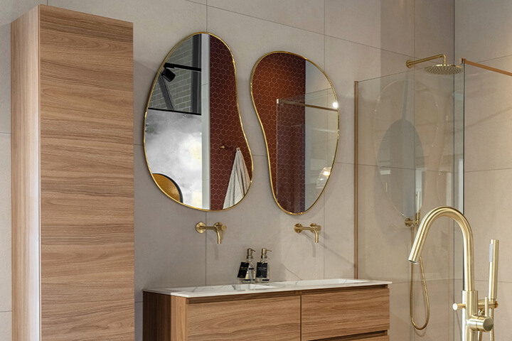 spiegel met organische vorm en gouden randje in badkamer